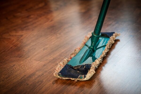 A cleaning mop on brown laminate floor