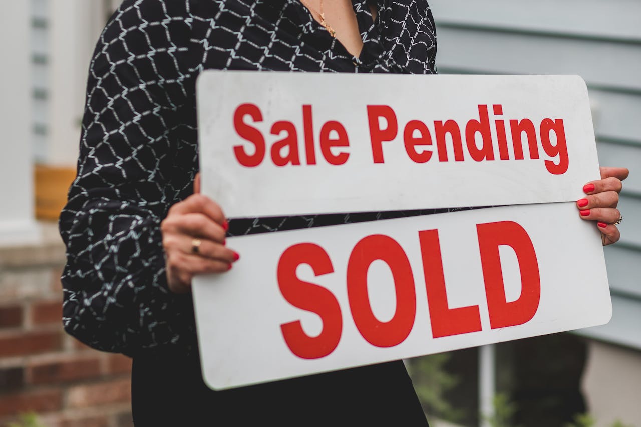 A woman holding signages for real estate selling