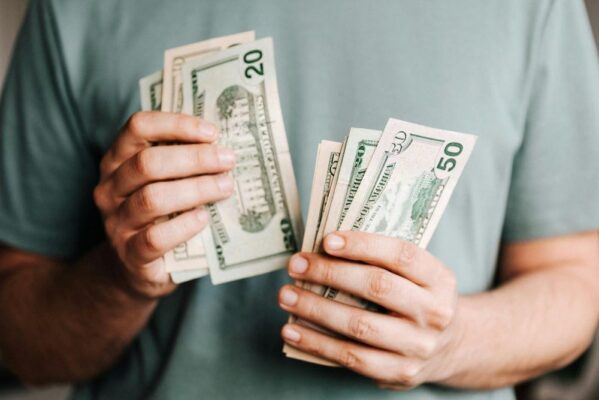 A man counting dollar bills in his hands