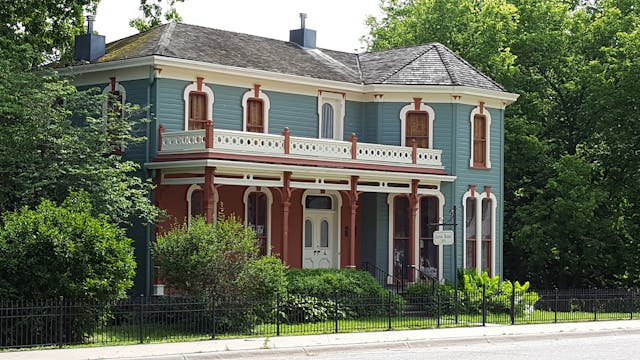 A beautifully preserved two-story historical home with intricate woodwork and vintage architectural details, ideal for selling a historical home to buyers seeking charm.