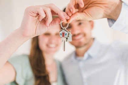 A couple holding and showing a house key